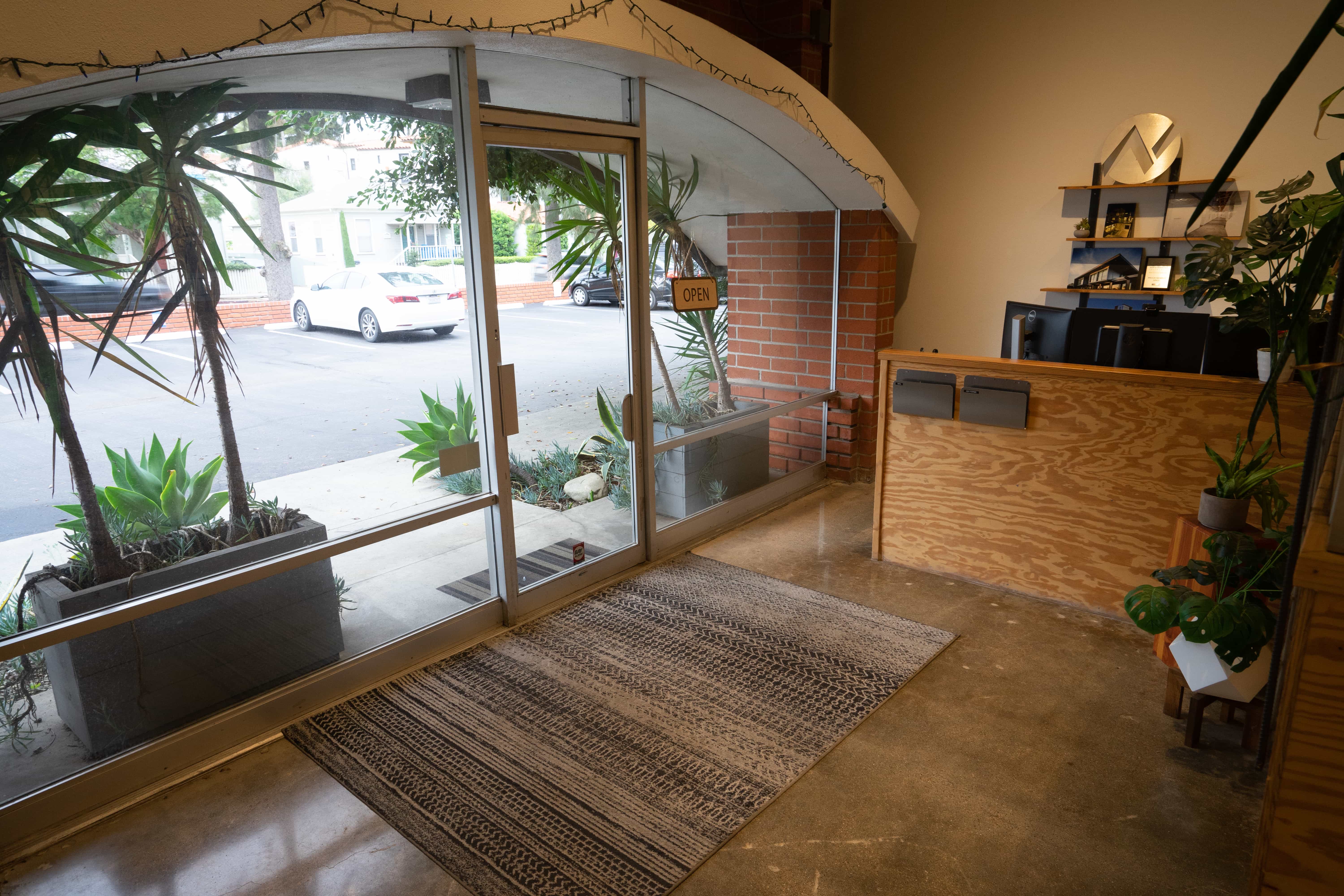 Arched brick entry with glass storefront and reception desk in Unit 210