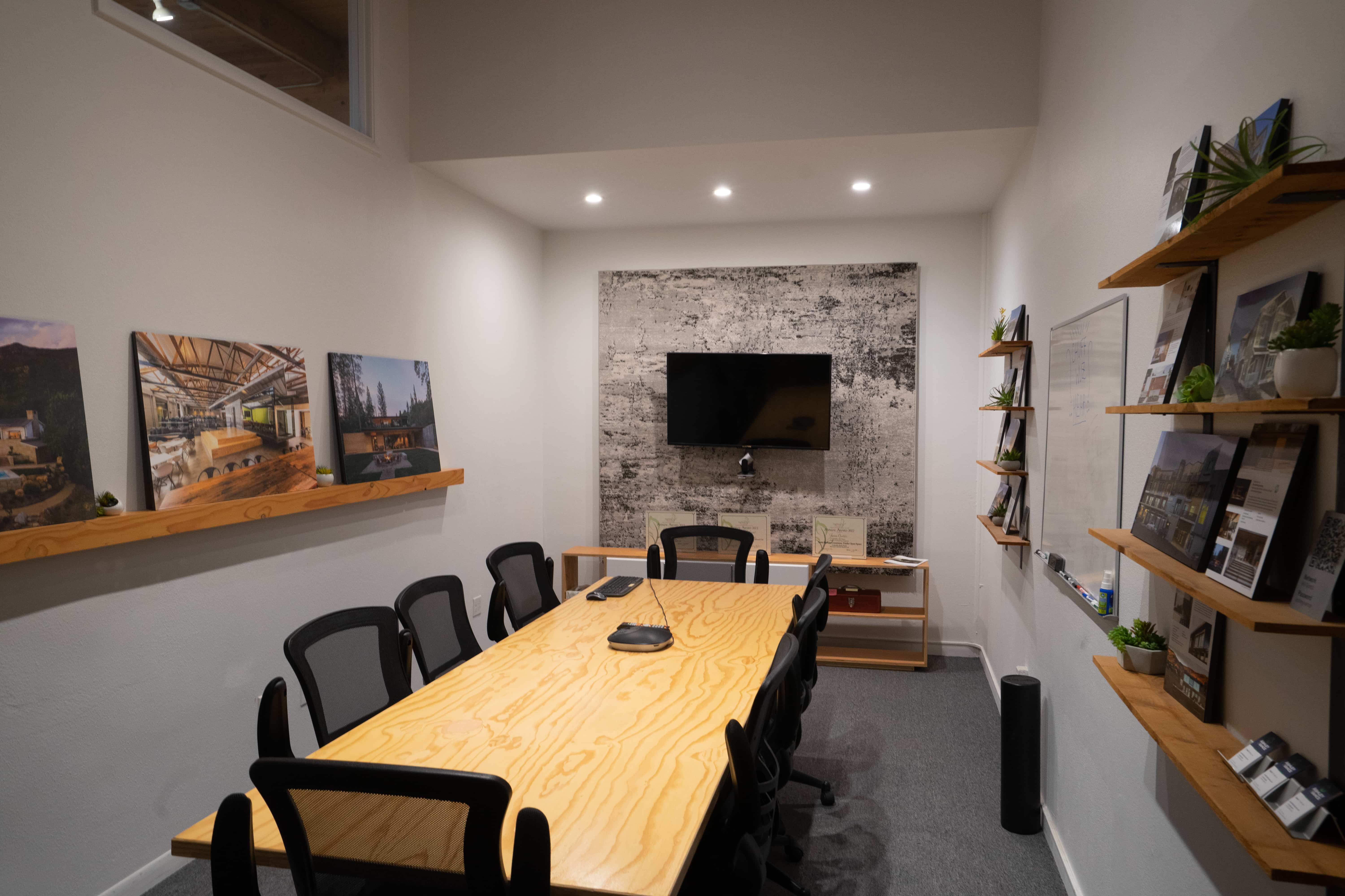 Conference room with a long wood table and display shelves in Unit 210