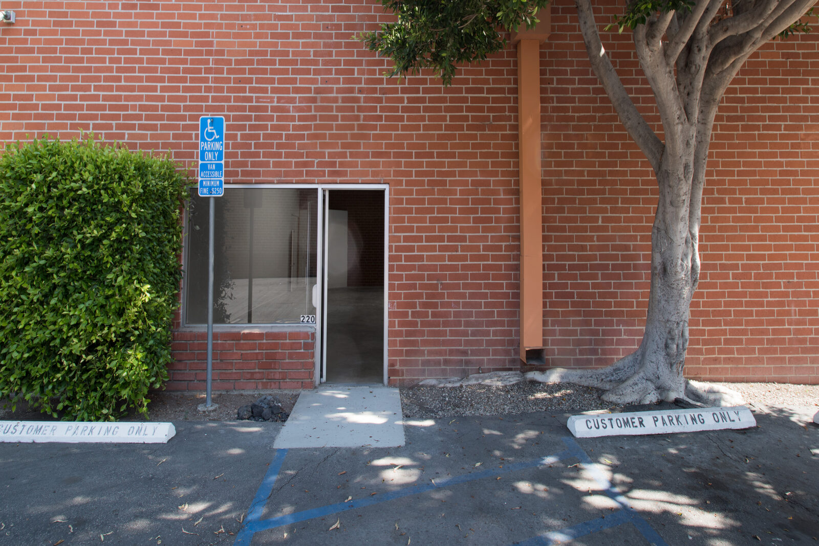 Brick exterior of Unit 220 with glass street entrance and accessible parking