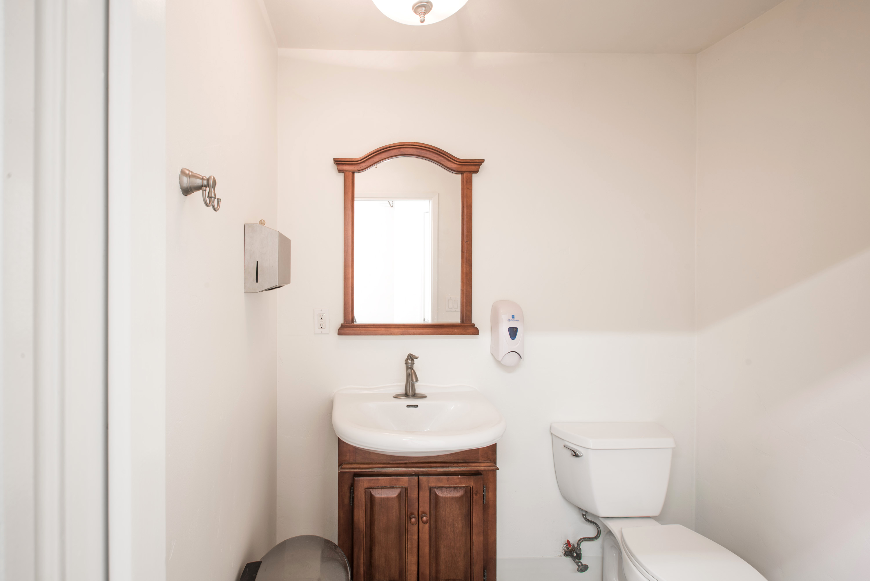 Bathroom with wood-framed mirror and vanity, shared finish for Units 218 and 220